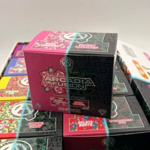 A 10-pack display box of Arcadia Fusion Pink Starburst and Berry Mimosa vapes resting on a master wholesale case.