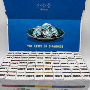 Open display box of Cook'd The Chef Sampler showing 50 individual kits.